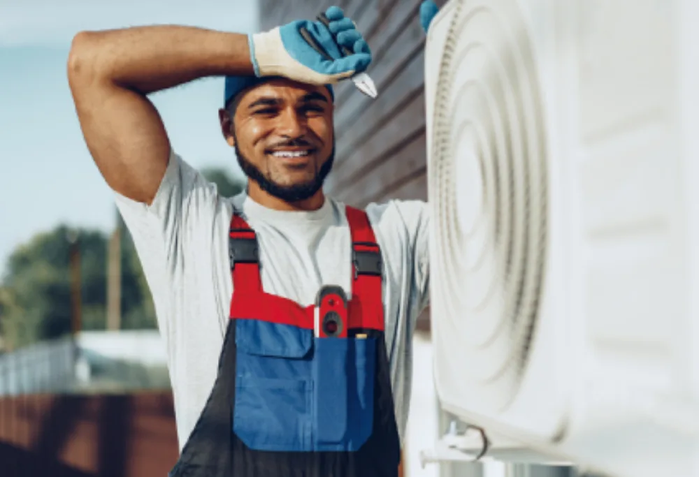 Technicien EUROMED souriant devant une unité de climatisation à Marseille